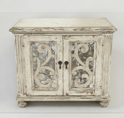 WOOD NIGHTSTAND WITH 2 AGED GLASS DOORS WITH SCROLLS DETAILS ON THE DOORS, RUSTIC FINISH IN VINTAGE WHITE